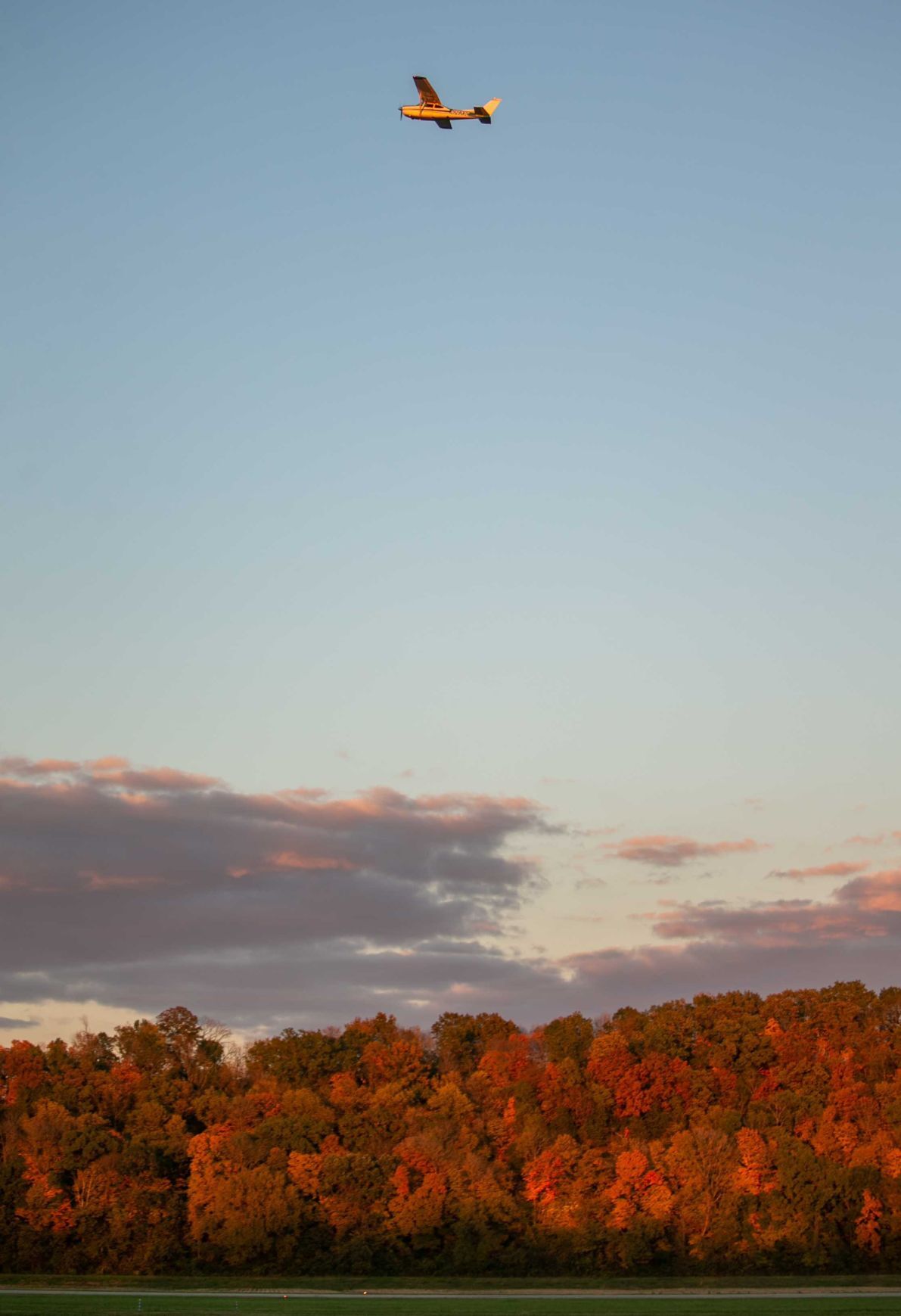 Prop plane takes off over fall colors